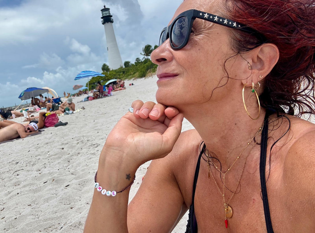 Frau am Strand mit Sonnenbrille und Kette von NeuGeliebt