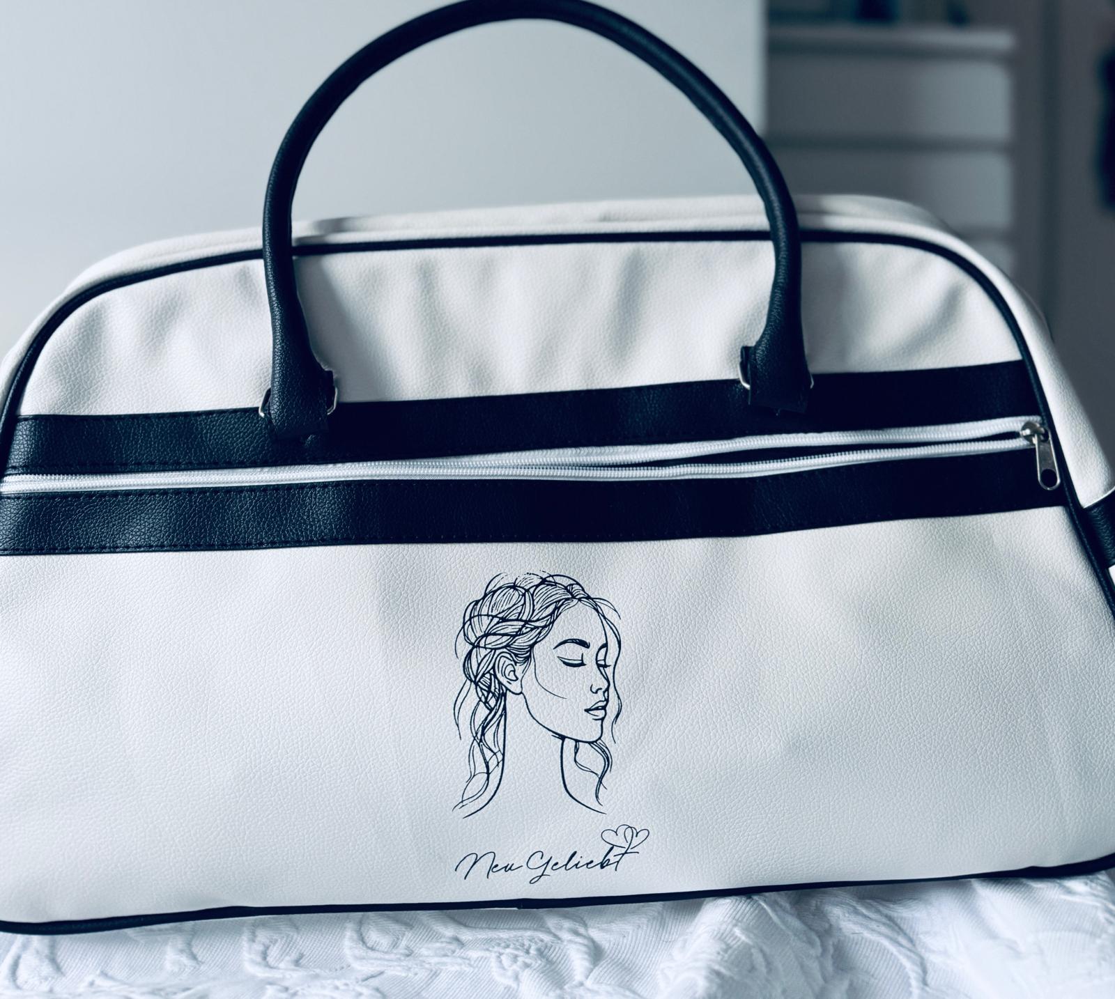 Schwarz-weiße Bowlingtasche mit dem Logo von NeuGeliebt. Nahansicht mit geöffneten Reßverschluss.