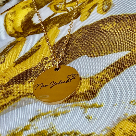 Anhänger mit Kette, goldfarben mit dem NeuGeliebt Logo.