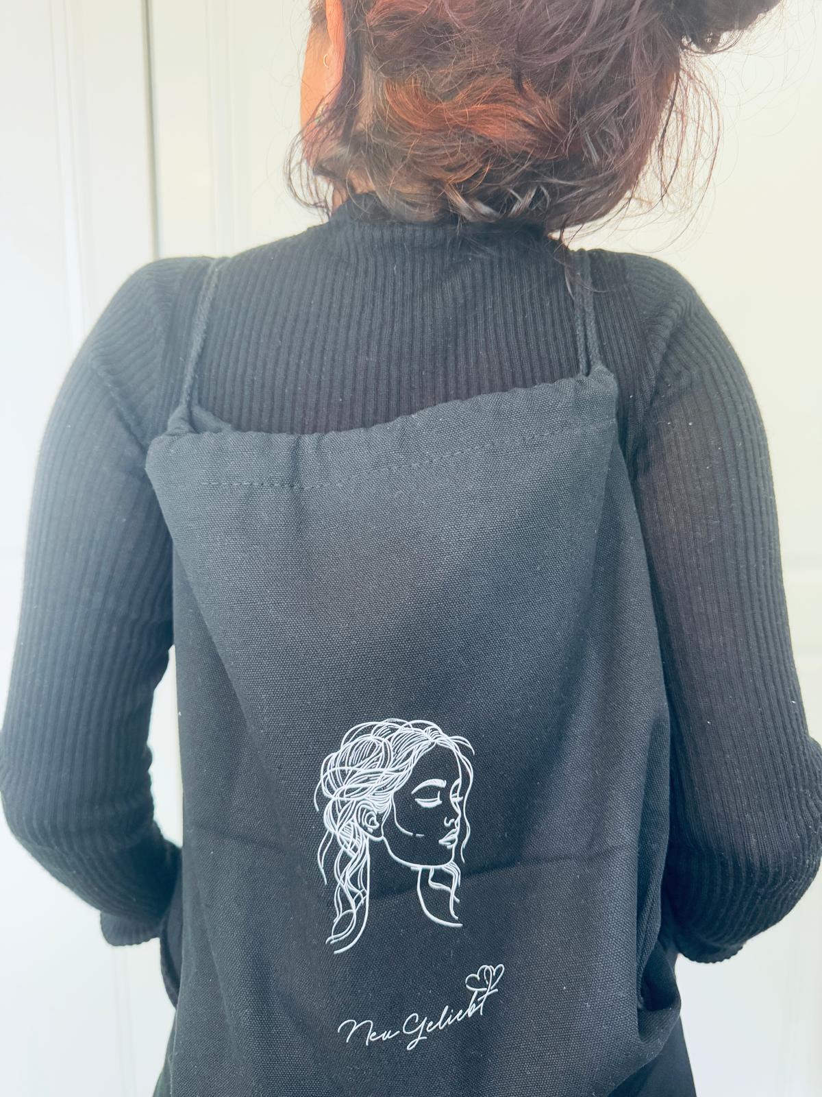 Frau mit schwarzem Rucksack auf dem Rücken aus Canvas mit Kordelzug.